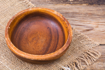 Wooden bowl on burlap, rustic table