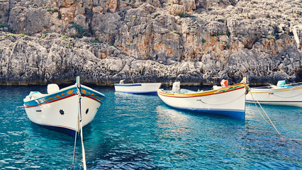The empty traditional Maltese boats Luzzu in the Blue Grotto Bay. Tourism low season concept