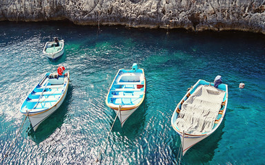 View of the empty traditional Maltese boats Luzzu in the Blue Grotto Bay. Tourism low season concept