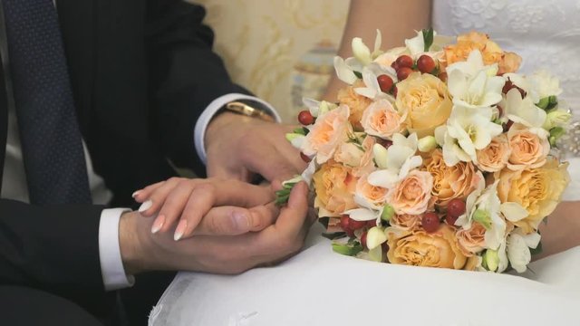 Bride and groom petting herself with palms at room of newlyweds. Close-up