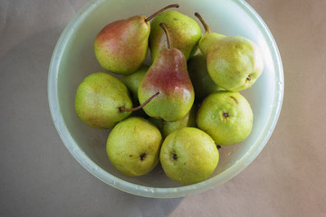 Fresh Anjou pears in a plastic bowl. Green with red sides