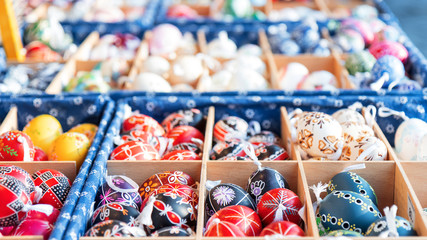 Wide selection of easter eggs, traditional souvenirs in the kiosk of street market during celebration of Easter in Central  Europe. Compartments full of colourfull eggs.
