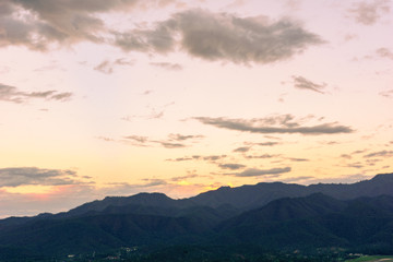 Amazing wild nature view of layer of mountain forest landscape with cloudy sky when sunset or twilight. Natural green scenery of cloud and mountain slopes background. Maehongson,Thailand