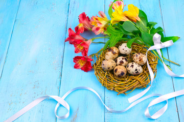 Spring background. Bouquet of flowers on a wooden background and a nest with eggs. spring