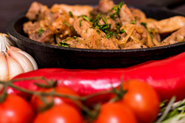 Fried pork in frying pan and vegetables