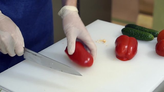Man's hands slicing sweet Red Bell Pepper on cutting board. Beautiful shot with soft focus. Healthy food concept
