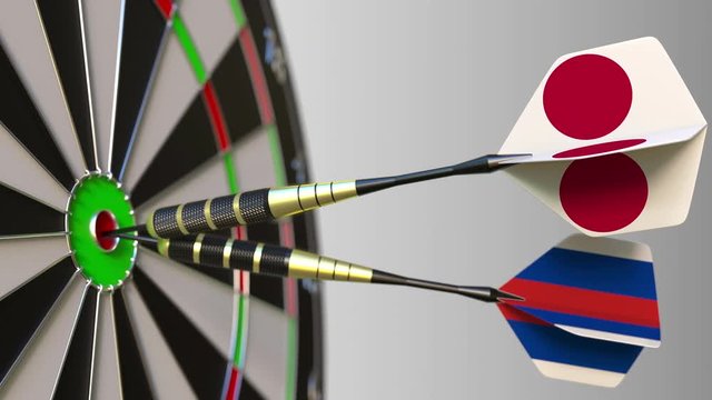 Flags of Japan and Russia on darts hitting bullseye of the target. International cooperation or competition conceptual animation