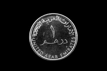 A macro image of a United Arab Emirates one dirham coin isolated on a black background