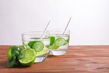 Tasty lemonade with cucumber, lime and mint in glasses on table