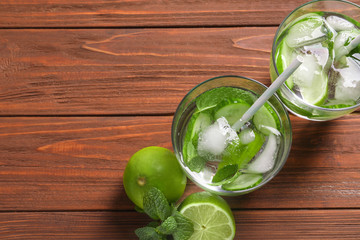 Tasty lemonade with cucumber, lime and mint in glasses on table