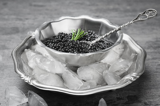 Black caviar served with ice on metal tray