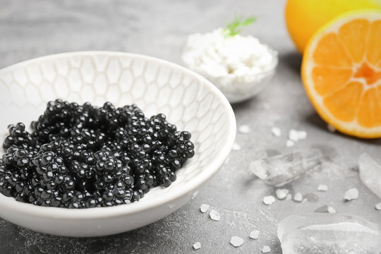 Bowl with delicious black caviar on table, closeup