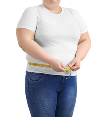 Overweight woman with measuring tape on white background
