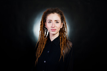 Studio shoot of girl in black with dreads at black background with nimbus.