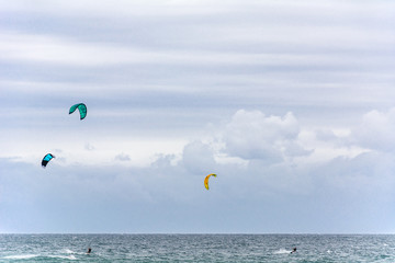 kitesurfers on the sea under an enormous sky.