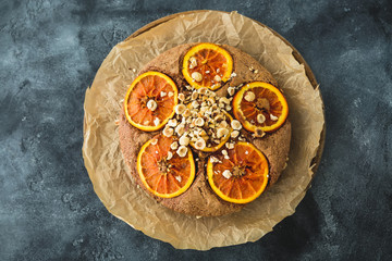 Delicious pie with citrus and nuts on board. Closeup view.