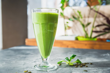 Green smoothie with spinach, banana, mango and pumpkin seeds.