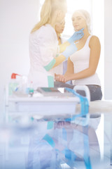 Fototapeta premium Beautiful woman face near doctor with syringe