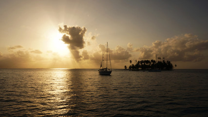 Fototapeta na wymiar The sun, a boat, and an island