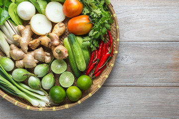 Mix of Thai vegetable in bamboo tray on wooden background.