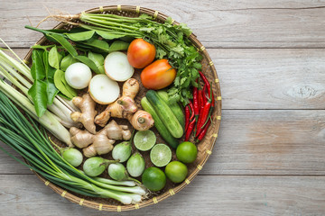 Naklejka na ściany i meble Mix of Thai vegetable in bamboo tray on wooden background.