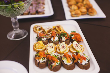 Beautifully decorated catering banquet table with different food snacks and appetizers on corporate christmas birthday party event or wedding celebration
