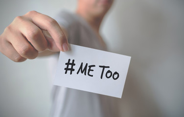 Close up hand of young man holding show a white card with word “Me Too”. Social movement concept