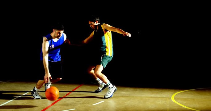 Competitors playing basketball in the court 