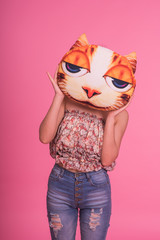 Young slim girl with a cat pillow over her face