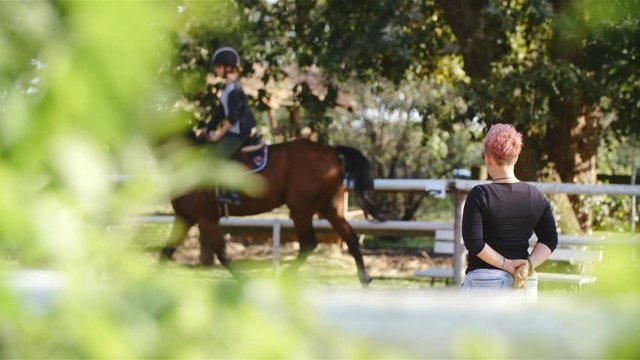 Short-haired female trainer watching over dressage rider 4K