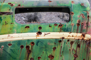 Rusty old car metal with bullet holes