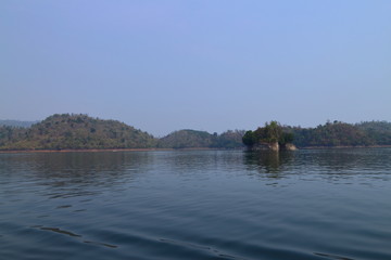 Mountain, lake and blue sky with white clouds in Kanchanaburi Province, Thailand.
