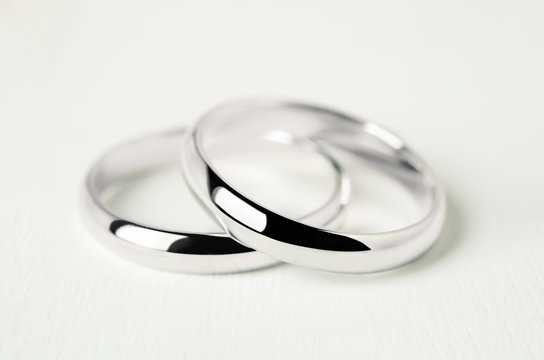 Couple wedding rings on white wooden background
