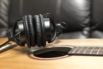 Obraz na płótnie Canvas Headphones Over Acoustic Guitar