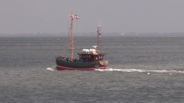 North Sea with cutter at the shores of Sylt, Germany. Kutter in der N&auml;he von Sylt.