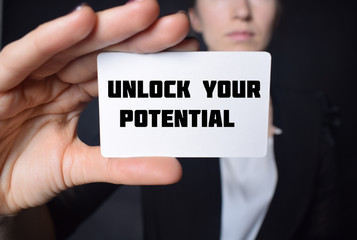 Businessman shows business card with the inscription:UNLOCK YOUR POTENTIAL