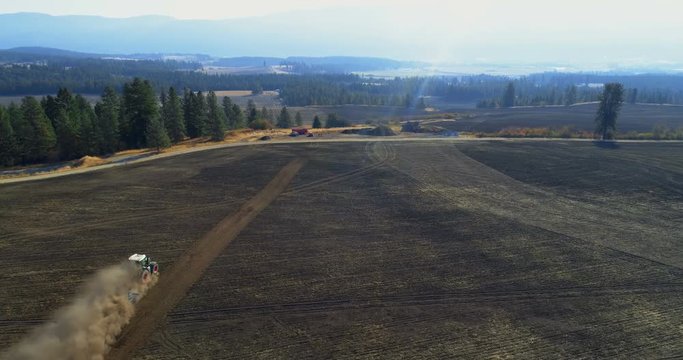 Aerial view of tractor moving on harvested field