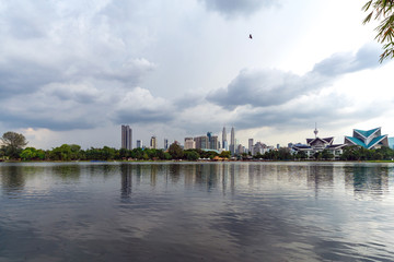 Fototapeta premium Zachmurzony widok na Kuala Lumpur z jeziora Titiwangsa. Jezioro znajduje się tuż obok ruchliwego Jalan Tun Razak w sercu Kuala Lumpur w Malezji.