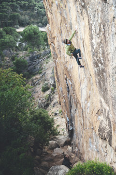 High angle view of Climber reaching across for handhold on rock face