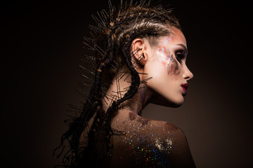 Mannequin met lichte make-up en kleurrijke glitter en glitters op haar gezicht en lichaam