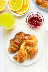 Breakfast with croissants, orange juice, raspberry jam