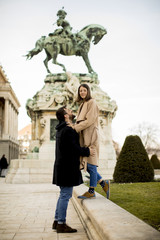 Loving couple outdoor with monument in background in Budapest