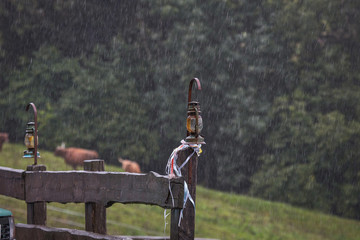 image of lanterns cutlery over wooden fence during rain