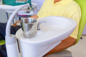 glass chromium on Sink medical equipment dentist Close up, ceramic spittoon and water filler in Clinic