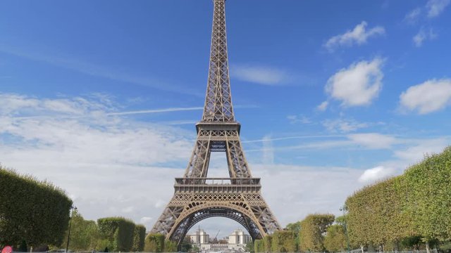 PARIS, FRANCE - SEPTEMBER 30, 2017: Tilt shot of the Eiffel Tower against the blue sky. Tourists taking shots and selfie at the bottom of famous city landmark