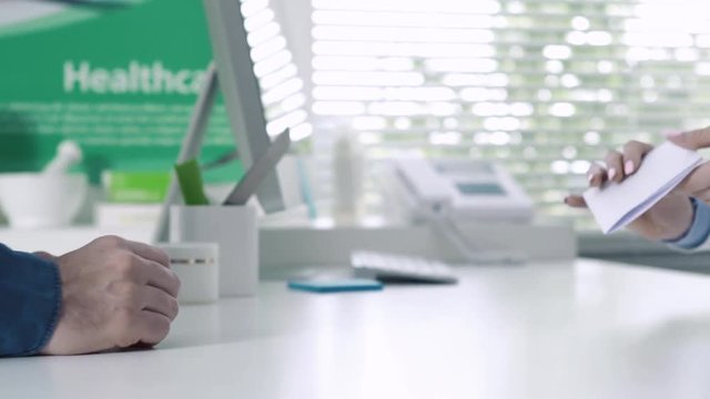 Customer giving a prescription to a pharmacist