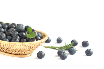 Fresh wild blueberries heap in wooden basket on white isolated background for wallpaper and all web design. Blueberry is healthy and delicious fruits which have high antioxidant and vitamin C.