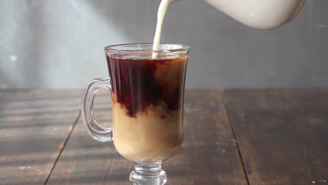 Milk is pouring into the coffee.