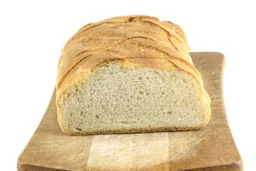 Fresh baked bread on wooden cutting board. Bun slice on isolated white background.