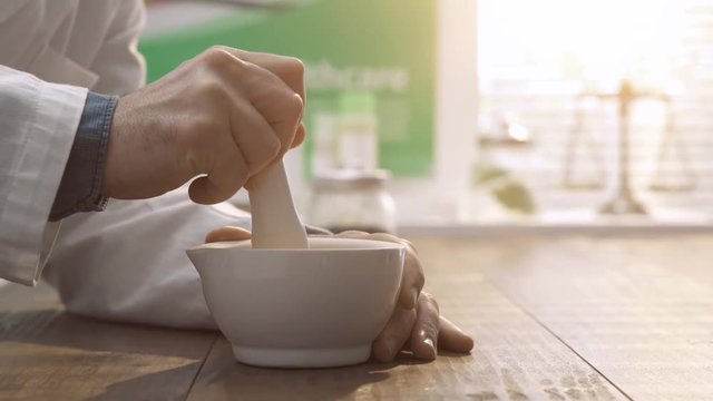 Pharmacist preparing natural remedies with mortar and pestle